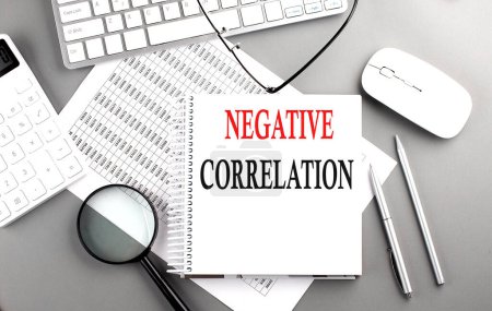 Photo for NEGATIVE CORRELATION text on notebook with clipboard and calculator on chart background - Royalty Free Image