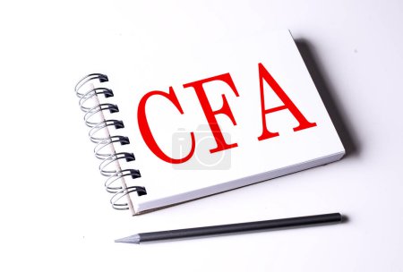 Téléchargez les photos : Texte CFA sur un carnet sur fond blanc, entreprise - en image libre de droit