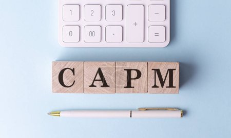 CAPM auf Holzwürfeln mit Stift und Taschenrechner, Finanzkonzept