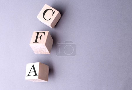Téléchargez les photos : Mot CFA sur un bloc de bois sur le fond gris - en image libre de droit