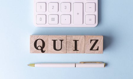 Photo for QUIZ on a wooden cubes with pen and calculator, financial concept - Royalty Free Image