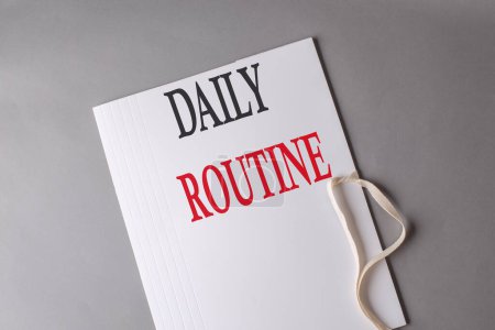 DAILY ROUTINE text on white folder on grey background
