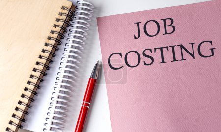 Photo for JOB COSTING word on pink paper with office tools on white background - Royalty Free Image
