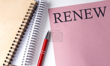 Téléchargez les photos : RENOUVEZ le mot sur papier rose avec des outils de bureau sur fond blanc - en image libre de droit