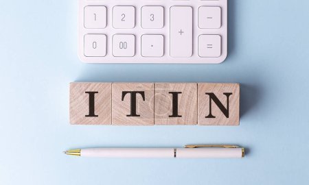 ITIN on a wooden cubes with pen and calculator, financial concept