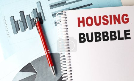 Photo for HOUSING BUBBLE text on notebook with pen on a chart background - Royalty Free Image