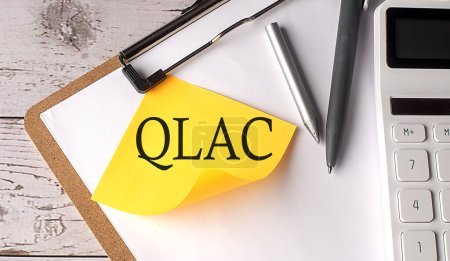 QLAC-Wort auf gelbem Klebeband mit Taschenrechner, Stift und Klemmbrett