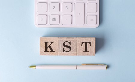 Téléchargez les photos : KST sur un cube en bois avec stylo et calculatrice, concept financier - en image libre de droit