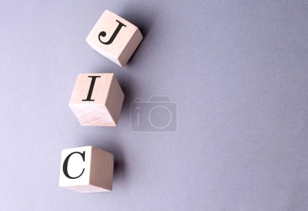Photo for Word JIC on a wooden block on the grey background - Royalty Free Image