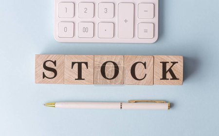 Photo for STOCK on a wooden cubes with pen and calculator, financial concept - Royalty Free Image
