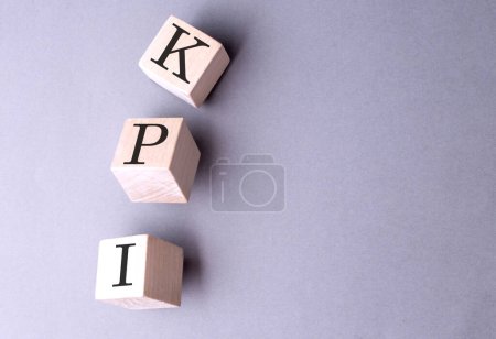 Téléchargez les photos : Mot KPI sur un bloc de bois sur le fond gris - en image libre de droit