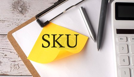 Téléchargez les photos : Mot SKU sur jaune collant avec calculatrice, stylo et presse-papiers - en image libre de droit