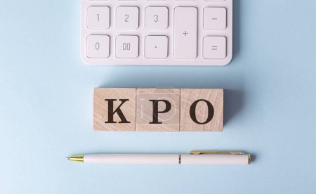 Téléchargez les photos : KPO sur un cube en bois avec stylo et calculatrice, concept financier - en image libre de droit