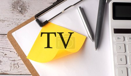 Foto de VALOR TERMINAL de TV palabra en amarillo pegajoso con calculadora, pluma y portapapeles - Imagen libre de derechos