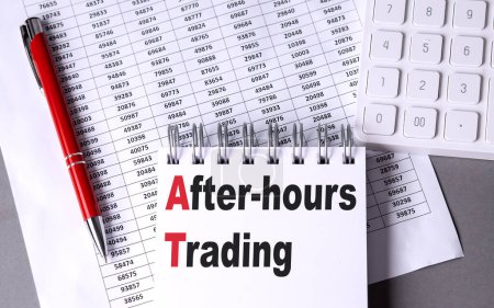 AFTER HOURS TRADING text on notebook with pen, calculator and chart on a grey background