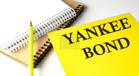 Foto de YANKEE BOND texto escrito en papel amarillo con cuaderno - Imagen libre de derechos