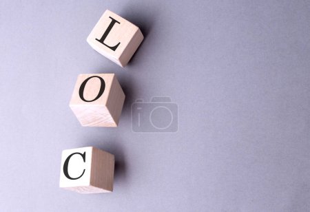 Foto de Palabra LOC sobre un bloque de madera sobre fondo gris - Imagen libre de derechos
