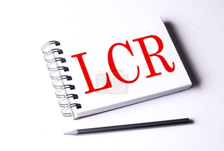Téléchargez les photos : Texte LCR- LIQUIDITY COVERAGE RATIO sur un carnet sur fond blanc, entreprise - en image libre de droit