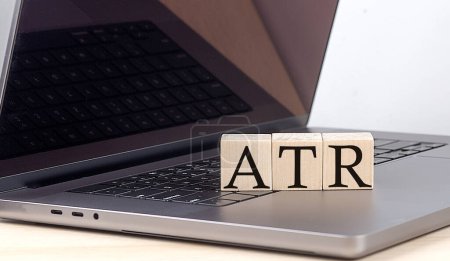 ATR palabra en un bloque de madera en el ordenador portátil, concepto de negocio