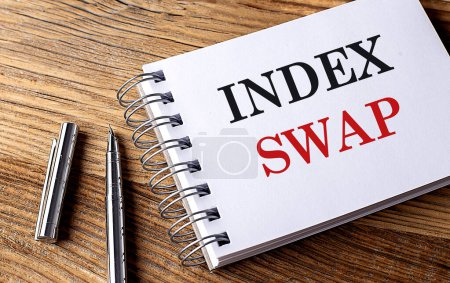 Téléchargez les photos : INDEX SWAP texte sur un carnet avec stylo sur fond bois - en image libre de droit