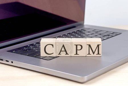 Téléchargez les photos : CAPM mot sur un bloc de bois sur ordinateur portable, concept d'entreprise - en image libre de droit