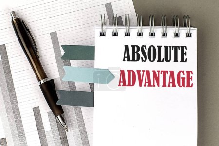 Photo for ABSOLUTE ADVANTAGE text on a notebook with pen, calculator and chart on a grey background - Royalty Free Image