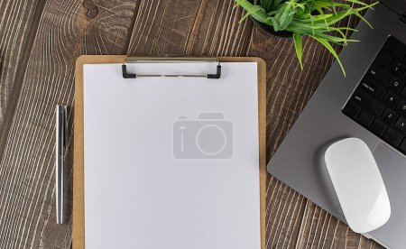 Téléchargez les photos : Presse-papiers et ordinateur portable sur une table en bois, espace de copie - en image libre de droit