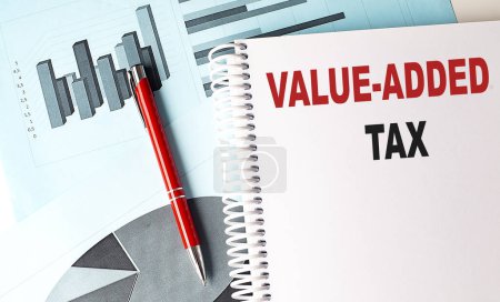 Photo for VALUE-ADDED TAX text on notebook with pen on a chart background - Royalty Free Image