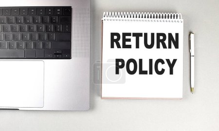 RETURN POLICY text on a notebook with laptop and pen