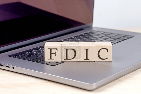 Photo for FDIC word on a wooden block on laptop, business concept - Royalty Free Image