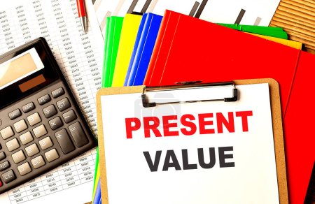PRESENT VALUE text written on a paper clipboard with chart and calculator