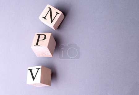 Word NPV auf einem Holzblock auf dem grauen Hintergrund