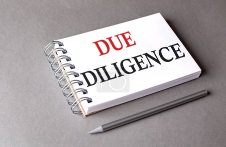 DUE DILIGENCE word on a notebook on grey background