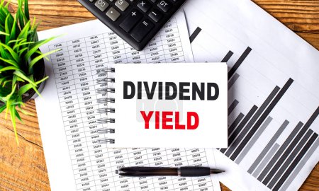 DIVIDEND YIELD text on notebook with chart and calculator