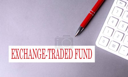 Téléchargez les photos : Exchange Traded Fund texte écrit sur fond gris avec stylo et calculatrice - en image libre de droit