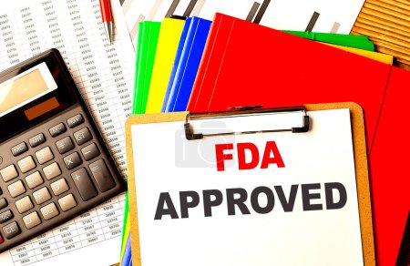 FDA aprobó texto escrito en un portapapeles con gráfico y calculadora