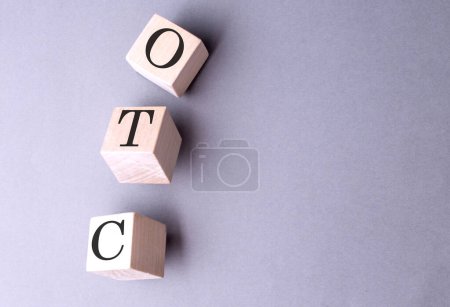 Word OTC Over The Counter auf einem Holzblock auf grauem Hintergrund