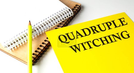 Quadruple Witching text written on yellow paper with notebook