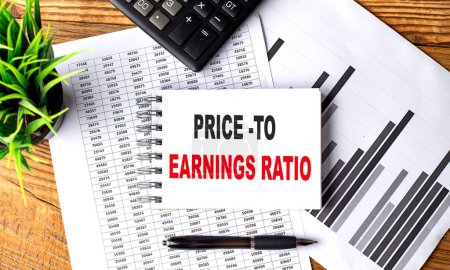 PRICE-TO EARNINGS RATO text on notebook with chart and calculator