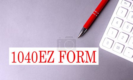 1040 EZ FORM text written on gray background with pen and calculator