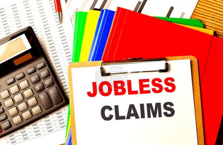Photo for JOBLESS CLAIMS text written on a paper clipboard with chart and calculator - Royalty Free Image