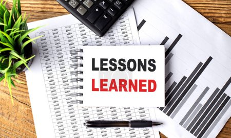 LESSONS LEARNED text on notebook with chart and calculator