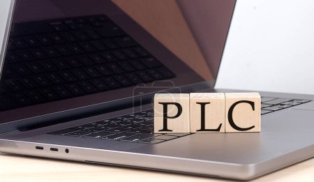 Foto de PLC palabra en un bloque de madera en el ordenador portátil, concepto de negocio - Imagen libre de derechos