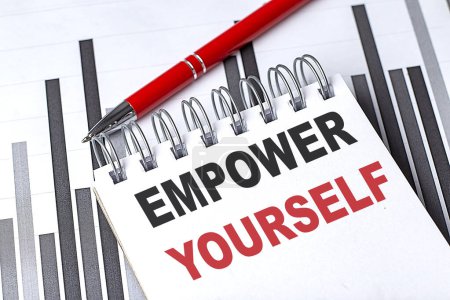 EMPOWER YOURSELF text written on a notebook with pen on chart