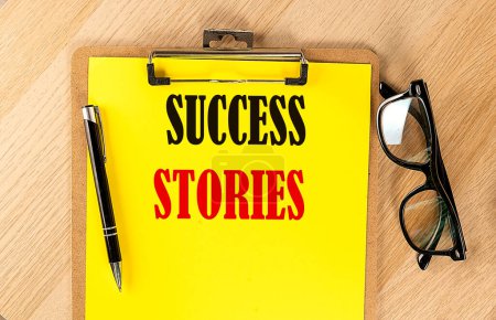 Photo for SUCCESS STORIES text on yellow paper on wooden background - Royalty Free Image