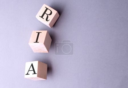 Palabra RIA en un bloque de madera sobre el fondo gris