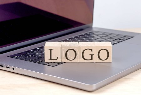 Foto de LOGO palabra en un bloque de madera en el ordenador portátil, concepto de negocio - Imagen libre de derechos