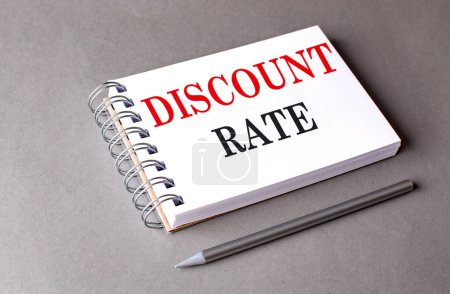 DISCOUNT RATE text on a notebook on grey background . 