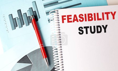 Photo for FEASIBILITY STUDY text on a notebook on chart background . - Royalty Free Image