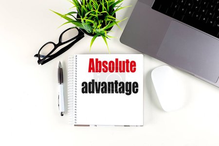 ABSOLUTE ADVANTAGE text on a notebook with laptop, mouse and pen . 